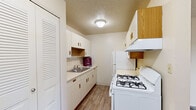 Located in Elkhart, Indiana, this single-floor unit offers three bedrooms, one full bathroom, and a efficiently designed layout. The galley-style kitchen is equipped with cream cabinetry featuring wood-tone hardware, a gas range, refrigerator, single-basin sink, and ample upper and lower cabinet storage, all set on wood-look vinyl flooring with a textured ceiling overhead. The three bedrooms are carpeted throughout and finished with neutral walls, offering a clean and versatile canvas. Each room benefits from natural light through window treatments, and select bedrooms include sliding glass door access to an outdoor balcony with exterior views of surrounding greenery. Built-in closets with louvered bifold doors provide organized storage. The full bathroom features a tub/shower combination with white surround, a toilet, and a vanity with sink, finished with wood-look flooring for a cohesive aesthetic. A connecting hallway ties the rooms together, allowing for a straightforward and practical flow throughout the unit. Textured ceilings are consistent across the space, contributing to the unit's understated residential character.