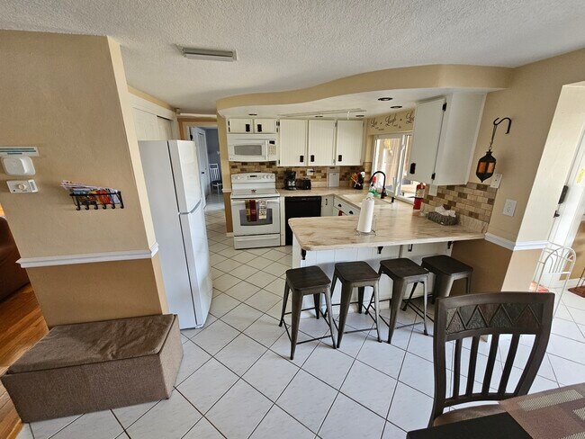 Área de cocina con barra para 4 personas. ¡Vistas al canal! - 3931 Sail Dr