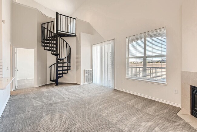 Un salón con escalera de caracol en Fox Run Lofts. - Fox Run Lofts