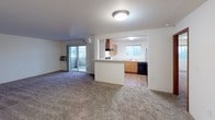 Located at 4034 Idlewild Loop in Coeur d'Alene, Idaho, this single-floor unit offers a practical and comfortable layout designed for everyday living. The open living area is finished with plush carpet and receives natural light through a sliding glass door that leads to a private balcony, providing pleasant outdoor views of the surrounding landscape.

The kitchen is connected to the living space via a pass-through counter opening, creating an accessible and functional flow between rooms. It is equipped with warm-toned wood cabinetry offering generous upper and lower storage, light-colored countertops, a double stainless steel sink, and black appliances including a refrigerator and dishwasher. A window above the sink frames scenic views of the treeline and hills beyond.

The bedrooms are carpeted and well-proportioned, each featuring sliding wood closet doors with built-in shelving and hanging rods. The neutral wall tones throughout keep the spaces feeling bright and versatile.

Two bathrooms serve the unit, both finished with wood-look flooring and warm wood cabinetry. One bathroom features a full tub and shower combination with chrome fixtures, while the other offers a vanity with a wide mirror and a high placement window for natural light. The overall design is clean and functional, making this a well-appointed space in a scenic Idaho setting.