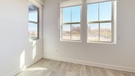 Located at 9465 W Post Rd in Las Vegas, NV, this well-appointed one-bedroom, one-bathroom unit offers a thoughtfully designed open-concept layout on a single floor. The heart of the home is a sleek, modern kitchen featuring a central island with a gas cooktop, a striking stainless steel range hood, white shaker-style cabinetry with glass-front upper panels, quartz countertops, a classic subway tile backsplash, and a full suite of stainless steel appliances including a French door refrigerator, wall oven, microwave, and dishwasher. The kitchen flows seamlessly into the combined dining and living area, all unified by warm wood-tone flooring throughout. The bedroom is a bright, comfortable retreat with a ceiling fan, sliding glass doors opening to a private balcony, and large windows that invite generous natural light and views of the surrounding Las Vegas skyline. The bathroom is finished in a clean, contemporary style with a full soaking tub, a wide vanity with quartz countertops, an illuminated mirror, and wood-look tile flooring. Additional features include an in-unit laundry, a utility room, and a dedicated closet, making this a functional and stylish urban residence.