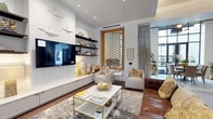 This single-floor space showcases a refined and cohesive interior design that balances modern sophistication with inviting warmth. The living area serves as the centerpiece, anchored by a sleek, wall-mounted entertainment unit finished in crisp white, complemented by open dark shelving displaying a curated collection of decorative objects and accessories. A large flat-screen television is seamlessly integrated into the media wall, creating a polished focal point.

Seating is thoughtfully arranged around a glass-and-gold coffee table atop a plush silver area rug, combining a tan leather sofa with light linen accent chairs accented by warm-toned throw pillows. The rich hardwood flooring adds depth and contrast to the otherwise light color palette.

A standout architectural feature is the ornate geometric lattice window framed in warm wood tones, which draws the eye and allows natural light to filter softly into the room. Floor-to-ceiling sheer grey curtains flank a glazed opening, further enhancing the sense of brightness and connection to the outdoors. Recessed ceiling lighting and a subtle tray ceiling detail add dimension overhead. White sculptural bird wall art introduces a playful artistic touch, completing the space's polished yet approachable character.