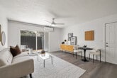 Located at 13130 Carriage Rd in Poway, CA, this thoughtfully updated single-floor residence offers a clean, modern aesthetic throughout. The open-concept living and dining area is anchored by light wood-style flooring, a ceiling fan, and a wall-mounted mini-split system. A sliding glass door floods the space with natural light and provides direct access to a private patio with views of surrounding greenery.

The kitchen is well-appointed with white shaker cabinetry, quartz countertops, stainless steel appliances including a French door refrigerator and dishwasher, a stainless range hood, and a peninsula that adds additional prep and casual dining space.

Two generously sized bedrooms each feature large windows with outdoor views, ceiling fans, and mini-split climate control units, creating bright and comfortable retreats. The primary bedroom includes a dedicated sitting area.

Two full bathrooms are finished in crisp white with wood-tone flooring and matte black hardware accents. One bathroom includes a soaking tub. A stacked in-unit washer and dryer adds everyday convenience.

Consistent wood-style flooring, white walls, and a neutral palette tie the space together, creating a cohesive and inviting atmosphere throughout.