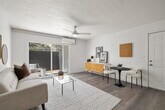 Located at 13130 Carriage Rd in Poway, CA, this thoughtfully updated single-floor residence offers a clean, modern aesthetic throughout. The open-concept living and dining area is anchored by light wood-style flooring, a ceiling fan, and a wall-mounted mini-split system. A sliding glass door floods the space with natural light and provides direct access to a private patio with views of surrounding greenery.

The kitchen is well-appointed with white shaker cabinetry, quartz countertops, stainless steel appliances including a French door refrigerator and dishwasher, a stainless range hood, and a peninsula that adds additional prep and casual dining space.

Two generously sized bedrooms each feature large windows with outdoor views, ceiling fans, and mini-split climate control units, creating bright and comfortable retreats. The primary bedroom includes a dedicated sitting area.

Two full bathrooms are finished in crisp white with wood-tone flooring and matte black hardware accents. One bathroom includes a soaking tub. A stacked in-unit washer and dryer adds everyday convenience.

Consistent wood-style flooring, white walls, and a neutral palette tie the space together, creating a cohesive and inviting atmosphere throughout.