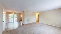 Located at 200 Country Club Ln in Anderson, South Carolina, this two-bedroom, two-bathroom residence offers a practical and comfortable single-floor layout. The living room is a generously sized, carpet-floored space bathed in natural light from a wide window with blinds, offering views of the surrounding greenery. Neutral-toned walls and a textured ceiling carry throughout, creating a consistent and understated aesthetic.

The kitchen features wood-style flooring, white cabinetry with ample upper and lower storage, white appliances including an electric range and refrigerator, a black dishwasher, and a built-in sink — all well-lit by a window overlooking the outdoors. Adjacent closet storage adds to the kitchen's practicality.

Both bedrooms are carpeted and feature neutral walls, windows with natural light, and generous closet space. The spacious primary bedroom is notably well-appointed with an expansive set of bifold closet doors spanning nearly the full wall, providing exceptional storage. The second bedroom is equally inviting with its own window view.

Each bathroom includes a tiled tub-shower combo with chrome fixtures and wood-style flooring, offering a clean, functional design. The overall layout is efficient and well-organized, making this a comfortable residence in Anderson, SC.
