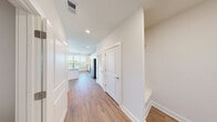 Located at 11201 Capital Blvd in Raleigh, NC, this well-appointed residence offers one bedroom and three bathrooms across a single floor of thoughtfully designed living space. The open-concept kitchen and living area serves as the heart of the home, featuring crisp white cabinetry, a classic subway tile backsplash, speckled granite countertops, and a central island with stylish pendant lighting. Stainless steel appliances, including a refrigerator, range, microwave, and dishwasher, complete the modern kitchen. Large windows flood the space with natural light and provide pleasant outdoor views of the surrounding Raleigh landscape. Warm wood-look plank flooring runs consistently throughout, complementing the clean white walls and bright, airy aesthetic. The spacious primary bedroom features corner windows on two walls, a ceiling fan, and generous proportions. The bathrooms maintain the home's modern palette, with one bathroom showcasing a tiled walk-in shower with a built-in bench seat and sleek horizontal tile detailing. A dedicated closet and a clean, well-lit hallway connecting all rooms add to the home's functional layout. Recessed lighting and ample natural light throughout create a welcoming and comfortable living environment.