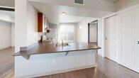 Located at 518 Coffman St in Longmont, Colorado, this single-floor, 2-bedroom, 2-bathroom residence offers a practical and well-organized layout across a comfortable footprint. Wood-style flooring runs consistently throughout the home, lending a cohesive and clean aesthetic to every room.

The open-concept living area flows directly into the kitchen, which features a peninsula with a built-in sink and dark countertops, warm-toned wood cabinetry, a range, and a full-size refrigerator. A ceiling fan overhead and vertical blinds covering a sliding glass door bring in natural light while allowing airflow into the living space.

Both bedrooms are bright and well-proportioned. The primary bedroom includes ample closet space, while the second bedroom features sliding panel closet doors and a window with natural light. Each room maintains a clean, neutral palette with white walls and light flooring.

The two bathrooms are finished with wood-toned vanity cabinetry, countertop sinks, and tile flooring accents. One bathroom includes a walk-in closet area, adding convenient storage. Additional closets are distributed throughout the unit, complemented by a dedicated laundry area and utility room, ensuring practical storage and functionality throughout the home.