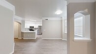 This single-story, 4-bedroom, 2-bathroom home in Houston, TX offers a well-organized layout designed for comfortable everyday living. The open-concept kitchen and living area form the heart of the home, featuring light wood-style flooring, neutral warm-gray walls, and crown molding accents. The kitchen is outfitted with crisp white shaker cabinetry, a subway tile backsplash, white quartz-style countertops, stainless steel appliances including a refrigerator, electric range, and microwave, as well as a double-basin sink. An arched entryway adds a classic architectural touch, connecting the kitchen to the rest of the home. Each of the four bedrooms is finished with the same light wood-style flooring, ceiling fans, and windows fitted with blinds that allow for natural light. The spacious primary bedroom includes dedicated closet space with wire shelving for organized storage. Both bathrooms feature white tile tub-and-shower combinations with clean, classic finishes. Additional highlights include multiple hallways for easy navigation, two laundry areas, and two closets providing ample storage throughout. The consistent neutral color palette and modern fixtures create a cohesive, move-in ready atmosphere across the entire home.