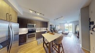 Located at 151 Southeast 3rd Avenue in Delray Beach, FL, this 2-bedroom, 1-bathroom residence offers a thoughtfully designed open-concept layout with cohesive, modern finishes throughout. Light wood-style flooring runs continuously across the living areas, enhancing the sense of flow and warmth.

The kitchen is a standout feature, equipped with stainless steel appliances — including a French door refrigerator, range, and microwave — dark espresso cabinetry extending to the ceiling, a classic white subway tile backsplash, and light stone countertops. A bar-height island with seating serves as both a dining and gathering space.

The open living area benefits from abundant natural light streaming through a sliding glass door that leads to a private balcony overlooking a lush outdoor setting. A ceiling fan keeps the space comfortable, and the open layout allows for flexible furniture arrangements.

The primary bedroom is generously sized, featuring a ceiling fan, a shuttered window with views of palm trees, and warm wood-toned storage. The second bedroom offers additional flexibility for guests or a home office. The bathroom includes a full soaking tub with floor-to-ceiling neutral tile surround. This residence combines contemporary design with a relaxed Florida lifestyle in a prime Delray Beach location.