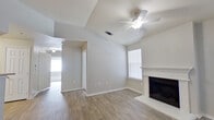 This single-story, 2-bedroom, 2-bathroom home offers a thoughtfully arranged floor plan that maximizes every square foot. The living room serves as the heart of the home, highlighted by a classic white-mantled fireplace, wood-look plank flooring, and a ceiling fan overhead. Vaulted ceilings lend a sense of openness, while multiple windows allow natural light to fill the space. A secondary door from the living area provides convenient outdoor access.

The kitchen features white cabinetry with ample upper and lower storage, light countertops in an L-shaped configuration, and black appliances including a range, built-in microwave, and dishwasher. Wood-look flooring continues throughout this functional cooking space.

Both bedrooms are carpeted for comfort and include double-door closets for storage. The primary bedroom offers generous proportions with a large window that brings in natural light. Each bedroom is served by its own full bathroom, both finished with white cabinetry, single-sink vanities, tiled tub-shower combinations, and light tile flooring, providing a clean and consistent aesthetic throughout the home. The neutral color palette across all rooms creates a bright, move-in ready environment.
