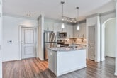 Located at 3848 Sautee Valley Dr in Duluth, GA, this single-floor residence offers a thoughtfully designed layout with a clean, contemporary aesthetic throughout. The kitchen serves as a central highlight, showcasing granite countertops, white shaker-style cabinetry extending to the ceiling, a stone tile backsplash, and a full suite of stainless steel appliances including a refrigerator, range, and microwave. A center island with a double undermount sink and pendant lighting overhead adds both function and style, while hardwood-style flooring anchors the space.

The open living area features crown molding, a tray ceiling, and French doors that invite natural light and provide outdoor access. Bedrooms are carpeted and generously sized, with multiple windows, ceiling fans, and built-in shelving in at least one room. The primary bathroom includes an L-shaped double vanity with granite countertops, tile flooring, and well-lit mirrors. A secondary bathroom mirrors the same quality finishes, offering a granite-topped vanity and a tiled shower-tub combo. The overall ambiance is bright, neutral, and move-in ready.