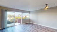 Located at 5060 La Jolla Blvd in the desirable 92109 zip code of San Diego, this single-floor residence offers a clean, modern aesthetic throughout. The open-concept living area is anchored by light-toned wood-style flooring and neutral gray walls, creating a bright and versatile canvas. A ceiling fan adds comfort and function to the spacious living room, which flows naturally toward a private balcony accessible through sliding glass doors. The balcony provides views of swaying palm trees and the surrounding neighborhood, bringing an unmistakable Southern California character to the space. Natural light pours in through multiple windows fitted with horizontal blinds, enhancing the airy feel of every room. The kitchen features a pass-through peninsula design with white cabinetry, white quartz-style countertops, subway tile backsplash, and a full suite of stainless steel appliances including a range, over-the-range microwave, dishwasher, and refrigerator. Light hardwood-style flooring in the kitchen complements the rest of the unit. The bedroom is generously proportioned with ample natural light and direct outdoor views. The bathroom is finished with a white undermount sink, stone-look countertop, a full tub/shower combination, and chrome fixtures throughout. Textured ceilings complete the interior details of this well-appointed San Diego residence.