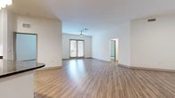 Located at 555 Promenade Pkwy in Irving, Texas, this single-story residence offers a well-organized layout with three bedrooms, three bathrooms, two closets, and a connecting hallway. The open living area is a central highlight, featuring light wood-look plank flooring, crisp white walls, and a ceiling fan overhead. French doors at the far end of the living space invite natural light and provide direct outdoor access, enhancing the bright, airy atmosphere. The kitchen is thoughtfully designed with warm wood-toned cabinetry, dark granite countertops on the island, a white tile backsplash, and a full suite of stainless steel appliances, including a side-by-side refrigerator, range, and microwave. The bedrooms are carpeted for comfort, each featuring windows with blinds that allow natural light while maintaining privacy. The primary bedroom includes access to a walk-in closet with built-in shelving and hanging rods. The bathrooms are finished with wood-grain vanity cabinetry, granite countertops, framed mirrors, and wood-look flooring, presenting a cohesive and modern aesthetic throughout the home.