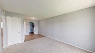 Located at 670 Maxey Rd in Houston, TX, this single-floor unit offers a practical and functional layout with two bedrooms, two bathrooms, two living areas, and dedicated laundry. The living areas feature a combination of plush carpet and wood-look flooring, neutral gray walls, and textured ceilings, creating a clean and cohesive aesthetic throughout. The galley-style kitchen is efficiently designed with gray cabinetry lining both walls, light marbled countertops, a double-basin sink, and included appliances such as an electric range and refrigerator, with light wood-look flooring completing the space. A door at the end of the kitchen provides additional access. Both bedrooms are carpeted and equipped with ceiling fans with light fixtures. The primary bedroom includes direct access to its own bathroom, while the second bedroom features a window that allows natural light to fill the room. The bathrooms are finished with light wood-look flooring, white vanities, and tub-shower combinations with tiled surrounds. Multiple closets throughout the unit provide ample storage, and a dedicated hallway connects the private areas of the home. The overall ambiance is clean, neutral, and move-in ready.