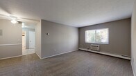 Located at 680 Smith Court in Rocky River, OH, this single-floor unit offers three bedrooms, one bathroom, a kitchen, and a dedicated entrance. The living area is carpeted in neutral tones and features a ceiling fan, textured ceiling, and a chair rail accent along the walls, lending a classic touch to the space. A window unit provides supplemental climate control, and baseboard heating runs throughout the home for consistent warmth. The generously sized primary bedroom is the standout room, offering ample space and natural light. The two additional bedrooms are also carpeted and feature windows with blinds that frame views of surrounding greenery, along with individual baseboard heaters. The kitchen is equipped with warm wood cabinetry, granite-style countertops, a stainless steel sink, and white appliances including an electric range and over-the-range microwave. The bathroom includes a full tub-shower combination with classic white tile accented by a dark tile border, complemented by tile flooring and a wood vanity. Neutral gray walls carry throughout the unit, creating a cohesive and clean aesthetic. The space is practical and well-organized, suited for comfortable everyday living.