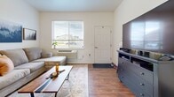 This one-bedroom, one-bathroom unit delivers a functional and welcoming single-floor layout designed for comfortable everyday living. Rich hardwood-style flooring flows consistently throughout the space, lending warmth and visual continuity from room to room.

The kitchen is well-appointed with warm-toned wood cabinetry, granite-style countertops, and a full suite of black appliances including a range, microwave, refrigerator, and dishwasher. A double-basin sink sits beneath upper cabinets, and a secondary exterior door provides convenient additional access.

The living area offers a comfortable, open feel with natural light streaming in through a large window fitted with blinds. A wall-mounted HVAC unit ensures climate control year-round, and the layout accommodates both a sectional sofa and entertainment setup with ease.

The bedroom is a quiet, restful retreat featuring a large window with neighborhood views, warm hardwood-style flooring, and a set of full-panel bi-fold closet doors offering generous storage.

The bathroom features matching wood cabinetry with granite-style countertops and a single-basin sink, maintaining the consistent design language found throughout the unit. A hallway connects the bathroom seamlessly to the main living area. The overall ambiance is clean, neutral, and move-in ready.