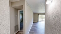 Located at 1055 Hickory Hill Lane in Nashville, TN, this one-bedroom, one-bathroom unit offers a functional and well-organized single-floor layout. The living room is a bright, open space featuring wood-style plank flooring, neutral beige walls, and a textured ceiling. A sliding glass door floods the room with natural light and provides direct access to a private balcony with views of surrounding greenery. The kitchen is efficiently designed with white cabinetry, light stone-tone countertops, a stainless steel sink, a dishwasher, and a white electric range — all finished in a clean, cohesive aesthetic with light hardwood-style flooring. The bedroom is a generously sized retreat, comfortably carpeted with soft gray tones, neutral walls, and a window that brings in natural light. It includes a built-in closet with bifold doors for ample storage. The bathroom features a full tub-shower combination with white tile surround, complemented by a patterned shower curtain and clean white fixtures. Two hallways connect the spaces seamlessly throughout the unit, contributing to a practical and easy-to-navigate floor plan. The overall ambiance is clean, neutral, and move-in ready.