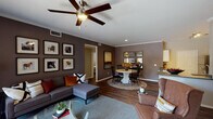 Located in Littleton, Colorado, this single-floor residence offers a thoughtfully designed layout that balances comfort and functionality. The open-concept living and dining area serves as the heart of the home, featuring rich hardwood-style flooring, crown molding, and a ceiling fan overhead. Deep taupe accent walls provide a warm backdrop, while a sliding glass door in the living area fills the space with natural light and provides access to an outdoor patio. The dining area transitions seamlessly from the living space, creating an inviting flow throughout.

The kitchen is equipped with stainless steel appliances, including a range, microwave, and refrigerator, complemented by white cabinetry, neutral countertops, and a undermount sink. Hardwood-style flooring continues throughout, adding visual continuity.

The bedrooms are generously sized, each featuring ceiling fans, large windows, and walk-in closets with built-in shelving for ample storage. One bedroom showcases a bold accent wall, adding a distinctive design touch.

The bathrooms are finished with white cabinetry, dark countertops, hardwood-style flooring, and tub-shower combinations. A spacious walk-in closet with multi-tier shelving and hanging rods adds notable storage capacity to the primary bedroom suite.