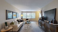 This 2-bedroom, 1-bathroom unit in St. Louis Park, Minnesota offers a practical and comfortable single-floor layout. The living room is a bright, welcoming space with large windows that invite abundant natural light and views of surrounding greenery, complemented by wood-style flooring that adds warmth throughout. Adjacent to the living area, the dedicated dining room features hardwood-style floors, a chandelier overhead, and its own window, making it an ideal space for meals and entertaining. The galley-style kitchen is efficiently designed with rich dark granite countertops, warm walnut-toned cabinetry, a double sink, and full appliances including a stacked washer/dryer unit conveniently tucked within. The spacious primary bedroom is carpeted for comfort, filled with natural light from a large window, and includes access to a walk-in closet with built-in shelving and hanging rods. The second bedroom also features carpet flooring and a bright window outlook. The full bathroom is finished with white tile surrounding a tub/shower combo and tile flooring. Four closets throughout the unit provide exceptional storage. Neutral tones and consistent finishes create a cohesive, move-in-ready atmosphere throughout.