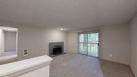 Located in Bremerton, WA, this single-floor, three-bedroom, three-bathroom home offers a functional and comfortable layout across a well-utilized footprint. The open living room is a welcoming space highlighted by a classic brick fireplace, plush carpeting, and a sliding glass door framed by vertical blinds that opens to a private balcony with views of surrounding greenery, allowing natural light to fill the room.

The galley-style kitchen is thoughtfully designed with white shaker cabinetry, dark countertops, light wood-look flooring, and black appliances including a refrigerator and electric range with overhead ventilation. Ample upper and lower cabinet storage, along with a built-in pantry closet, adds to the kitchen's practicality.

Each of the three carpeted bedrooms offers a comfortable, neutral palette with windows that bring in natural light. The spacious primary bedroom provides a generous personal retreat. The three bathrooms include clean, white finishes — one featuring a tub-shower combination with brushed gold fixtures, and another with a white vanity, dark countertop, and light hardwood-style flooring. A dedicated laundry area and five closets add to the home's storage and convenience. Textured ceilings are consistent throughout the home.