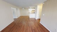 Located at 15541 Williams St in Tustin, California, this single-floor residence offers a practical and well-organized layout designed for comfortable everyday living. The open-concept living and dining area is anchored by warm-toned hardwood-style flooring that extends throughout the main living spaces, creating a cohesive and inviting atmosphere. A ceiling fan with integrated lighting provides both air circulation and illumination, while textured ceilings add a classic residential character throughout.

The kitchen is positioned at the heart of the home, featuring a peninsula counter that separates it from the living area. White cabinetry lines the walls, offering ample storage, and recessed lighting brightens the workspace. A white electric range, under-cabinet range hood, and a single-basin sink complete the functional kitchen setup. Granite-style laminate countertops add a clean, polished finish.

The bedrooms are carpeted for comfort and each include a ceiling fan with light fixture. One bedroom benefits from a window with vertical blinds, allowing natural light and outdoor views. Louvered closet doors are present in multiple areas, providing organized storage throughout the unit. The bathroom is clean and straightforward, featuring a full soaking tub with shower surround, a toilet, and a grab bar, all finished in white for a bright, sanitary feel.