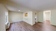 Located at 250 Treetops Drive in Highland Park, NJ, this 2-bedroom, 2-bathroom residence offers a well-organized single-floor layout designed for comfortable everyday living. Warm-toned hardwood-style flooring runs throughout the entire unit, creating a cohesive and clean aesthetic from room to room.

The open living room is generously proportioned, bathed in natural light from large windows dressed with vertical blinds, and features a baseboard heating unit along the exterior wall. A convenient pass-through window connects the living area to the kitchen, enhancing the sense of openness. The galley-style kitchen is efficiently laid out with ample light wood cabinetry on both sides, white countertops, a stainless steel sink, and white appliances including a coil-top range and full-size refrigerator.

The primary bedroom offers a comfortable footprint with a large window providing natural light and outdoor views, complemented by a wall-mounted HVAC unit. The second bedroom is equally bright and well-proportioned. A dedicated closet with double doors provides additional storage. Both bathrooms are functional and well-appointed, one featuring a full tub/shower combination. A utility area with an electrical panel is also accessible within the unit.