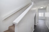 Located at 1416 W Kendall Dr in San Bernardino, CA, this two-story home offers a straightforward, functional layout distributed across both levels. The main living area features wood-look flooring and is bathed in natural light through a sliding glass door that opens to a fenced outdoor space, providing a seamless connection between interior and exterior. An additional window further brightens the room, creating a welcoming atmosphere.

The kitchen is generously proportioned, featuring white cabinetry in abundance, light-toned countertops, a built-in sink, and a skylight-style overhead fixture that enhances brightness. Wood-look flooring continues throughout, and the layout allows for easy flow into adjacent areas, including the staircase leading to the upper level.

Upstairs, a hallway with wood-look flooring connects the rooms, with carpeted bedrooms offering a softer underfoot feel. Each bedroom includes vertical blinds and windows that allow natural light in. Bathrooms are clean and practical, with one featuring a soaking tub and the other a toilet and towel bar. Textured ceilings are present throughout, and the overall aesthetic is neutral and move-in ready.