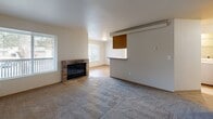 Located in Lakewood, WA, this well-appointed one-bedroom, one-bathroom unit offers a thoughtful single-floor layout that maximizes every square foot of its comfortable living space. The open living and dining area is anchored by a classic brick wood-burning fireplace and large windows that invite natural light and offer views to the private balcony beyond. Soft carpet throughout the main living areas and bedroom provides warmth underfoot, while the kitchen and hallway feature light hardwood-style flooring for easy maintenance. The kitchen is equipped with warm wood cabinetry, a white electric range, a full-size refrigerator, and generous counter space, opening conveniently toward the dining area via a pass-through. The generously sized bedroom features a large double-door closet and a bright window overlooking the surrounding neighborhood. The full bathroom includes a tub/shower combo with clean, neutral finishes. A dedicated laundry room with a full-size washer and dryer adds everyday convenience. A hallway closet provides additional storage. The private balcony rounds out this unit, offering an outdoor retreat. This space is practical, comfortable, and well-suited for those seeking a functional home in Lakewood.