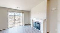 This single-floor residence offers a thoughtfully designed open-concept layout finished in a clean, neutral palette throughout. The living area serves as the heart of the home, anchored by a classic white-mantled fireplace with mosaic tile surround and complemented by smooth hardwood-style flooring. A large sliding glass door floods the space with natural light and provides access to an outdoor balcony with views of the surrounding area.

The kitchen is well-equipped for everyday living, featuring white shaker-style cabinetry, granite countertops, a peninsular breakfast bar, recessed lighting, and a full suite of stainless steel appliances including a refrigerator, range, microwave, and dishwasher. The open pass-through design connects the kitchen seamlessly to the main living space.

The bedrooms offer comfortable retreats with plush carpeting, generous closet space — including a spacious walk-in closet with wire shelving — and ample room for furnishings. The two bathrooms are well-appointed with white cabinetry, granite vanity countertops, and hardwood-style flooring. One bathroom features a walk-in shower, while the other includes a full tub/shower combination. The overall design is clean, modern, and move-in ready.