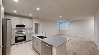 Located at 1610 Campbell Road in Houston, TX, this well-appointed single-story home offers two bedrooms and two bathrooms with a clean, modern aesthetic. The open-concept kitchen and living area serves as the heart of the home, anchored by a large central island topped with granite countertops and an undermount sink. White shaker-style cabinetry, a classic subway tile backsplash, and a full suite of stainless steel appliances — including a French door refrigerator, microwave, and range — complete the kitchen. Light wood-style flooring runs throughout the home, lending a bright, cohesive feel. The living area benefits from natural light through a window fitted with blinds and is equipped with a ceiling fan. Both bedrooms are generously sized, each featuring ceiling fans, natural light from windows, and light wood flooring. The spacious primary bedroom includes a walk-in closet with built-in wire shelving for ample storage. The primary bathroom features a granite-topped vanity with shaker cabinetry, a large mirror, and a tiled walk-in shower. The secondary bathroom offers a tub-shower combination with elegant marble-style tile surround. Two dedicated closets provide additional storage throughout the home.