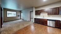 Located at 4770 Timber Pkwy S in Fargo, North Dakota, this well-appointed 2-bedroom, 2-bathroom unit offers a practical and comfortable single-floor layout. The kitchen is equipped with stainless steel appliances — including a refrigerator, range, and over-the-range microwave — complemented by rich dark-stained cabinetry and light countertops. Wood-look flooring runs through the kitchen and entry areas, transitioning to plush carpeting in the living room and bedrooms, creating a warm and inviting atmosphere.

The open-concept layout connects the kitchen seamlessly to the living area, which features a large window allowing natural light to fill the space. Each bedroom is generously sized, with the primary bedroom offering ample room and its own dedicated walk-in closet fitted with wire shelving systems. A second walk-in closet provides additional storage. Both bathrooms feature dark wood vanities with undermount sinks and neutral countertops, with one bathroom including a shower-tub combo.

A dedicated in-unit laundry room accommodates a full-size washer and dryer side by side, complete with overhead shelving for added storage. Neutral wall tones, dark wood trim, and baseboard heating are consistent throughout, contributing to a cohesive and functional living space.