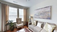 This single-floor 2-bedroom, 2-bathroom residence combines modern design with comfortable living. The living area serves as the heart of the home, featuring warm hardwood flooring, neutral-toned walls, and large windows dressed with elegant curtains and horizontal blinds that allow an abundance of natural light to fill the space. The room is thoughtfully proportioned, offering ample space for comfortable seating arrangements, complemented by tasteful décor including a large abstract wall painting that adds a sophisticated artistic touch. The bright, airy atmosphere is enhanced by clean white ceilings with contemporary lighting fixtures. The open and functional layout flows naturally between spaces, creating a sense of continuity and ease of movement throughout the home. Neutral color palettes and carefully chosen furnishings contribute to a calm, cohesive aesthetic that feels both welcoming and refined. The two bedrooms provide private retreats, while the two full bathrooms ensure convenience for residents and guests alike. Overall, this residence strikes a balance between practicality and style, making it an ideal space for those seeking a comfortable, well-designed home with a bright and serene atmosphere.