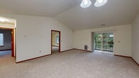 Located at 17465 W River Birch Dr in Brookfield, WI, this single-floor, 2-bedroom, 2-bathroom home offers a well-organized layout with comfortable living spaces throughout. The open living room is a highlight of the home, featuring vaulted ceilings that add a sense of spaciousness, plush carpeting, and sliding glass doors that lead to an outdoor deck overlooking lush greenery — filling the room with natural light and views of the surrounding landscape. Adjacent to the living area, the galley-style kitchen is equipped with warm wood cabinetry, a stainless steel sink, a full suite of white appliances including a refrigerator, range, and dishwasher, and durable hardwood-style flooring. The generously sized primary bedroom features vaulted ceilings, plush carpeting, and warm wood-trimmed doors and baseboards. The second bedroom is well-proportioned with a large window that brings in natural light. Both bedrooms are served by their own bathrooms — one featuring a full tub/shower combo and the other a standalone glass-door shower stall. Warm wood trim and neutral tones are consistent throughout the home, lending a cohesive and inviting character to every room.