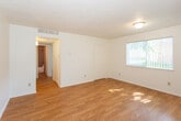 Located at 300 Dorado Pl SE in Albuquerque, New Mexico, this single-floor home offers a practical and comfortable layout with a variety of functional spaces throughout. The living area is bright and open, featuring warm hardwood flooring that extends throughout much of the home, white walls, and a textured ceiling. Large windows with vertical blinds allow natural light to fill the space, creating a welcoming atmosphere. The living area flows conveniently toward the kitchen, which is well-appointed with rich wood cabinetry, laminate countertops, a gas range, a double-basin sink, and a dishwasher — providing ample storage and workspace for everyday use. The bathroom is finished with warm earth-toned tile surrounding a full soaking tub and shower, complemented by a wood-vanity with a stone-finish countertop and hardwood flooring. A carpeted bedroom with a distinctive painted brick accent wall and a window offering natural light adds a unique character to the home. Additional rooms feature hardwood flooring, closet access, and neutral tones throughout, lending a clean and versatile canvas. The overall ambiance of this home is practical and inviting, with consistent finishes and a cohesive design well-suited for comfortable everyday living.