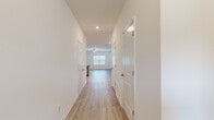 This two-story home offers a thoughtfully designed layout across two floors, combining functional living spaces with clean, modern finishes. The main floor features an open-concept kitchen and living area, where the kitchen stands out with white cabinetry, granite countertops, stainless steel appliances including a refrigerator, range, microwave, and dishwasher, and a undermount sink. Light hardwood-style flooring flows consistently throughout both levels, adding warmth and continuity to the interior.

The upper floor hosts the three bedrooms, two full bathrooms, a hallway, a closet, and a dedicated laundry room. The spacious primary bedroom features a tray ceiling with crown molding, a ceiling fan, a walk-in closet with wire shelving, and a private en-suite bathroom. The additional bedrooms offer ample space, double-door closets, and easy access to the shared bathroom, which includes a full soaking tub and shower combo with chrome fixtures.

The hallway connecting the bedrooms is bright and clean, with recessed lighting guiding the way to the open living area below. The laundry room accommodates a full-size washer and includes overhead wire shelving for added storage. Throughout the home, crisp white walls, recessed lighting, and ceiling fans contribute to a fresh, move-in-ready atmosphere.