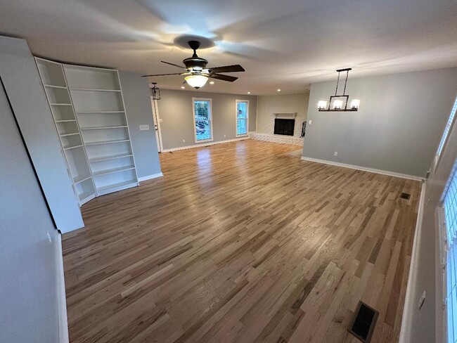 Sala de estar trasera, comedor y vista a la sala de estar delantera con chimenea - 4737 E Circle Dr NW