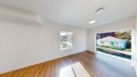Located at 3417 Harbor Ave SW in Seattle's Harbor Avenue corridor, Unit 411 is a thoughtfully designed two-bedroom, two-bathroom residence that makes efficient use of its single-floor layout. Warm wood-style flooring runs consistently throughout, lending a cohesive and modern aesthetic to every room.

A central hallway connects the living spaces, with natural light filtering in through multiple windows that frame views of the surrounding neighborhood. The kitchen features light wood cabinetry, a stainless steel refrigerator, and a single-basin sink — a clean, functional space designed for everyday use.

Both bedrooms are bright and simply finished, with crisp white walls and windows that invite natural light. The primary bedroom includes a sliding glass door that opens to an outdoor view, adding a sense of openness. The second bedroom is more compact, with a wall-mounted ventilation unit and ample wall space.

The two bathrooms are finished in a clean, modern style. One features a full soaking tub with a shower, a wood-toned vanity, and chrome fixtures. The second bathroom offers a walk-in shower with the same consistent flooring and neutral palette found throughout the unit.

Overall, the space presents a clean, contemporary atmosphere with a practical layout well-suited for urban living in Seattle.