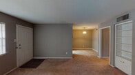 Located at 600 Nottingham Oaks Trail in Houston's 77079 zip code, this single-story home offers a practical and straightforward layout across its well-defined living spaces. The living and dining areas flow openly into one another, with warm neutral-toned carpet underfoot, textured ceilings, and a pendant light fixture anchoring the dining space. The transition from the entry features durable hardwood-style flooring that gives way to the carpeted main areas.

The kitchen is equipped with white cabinetry, granite-style laminate countertops, a black refrigerator, and a black coil-burner electric range with an overhead exhaust hood — providing all essential cooking amenities in a compact, efficient layout.

The bedrooms are carpeted and painted in soft gray tones, each benefiting from ceiling fan light fixtures and window blinds that allow for natural light and ventilation control. Closet access is provided via sliding louvered or standard doors, offering practical storage solutions.

The bathrooms feature dark hardwood-style flooring, white tile tub-shower surrounds, vanities with granite-style countertops, and white cabinetry. One bathroom includes a dedicated water closet for added privacy. Overall, the home presents a clean, functional interior suited for comfortable everyday living.