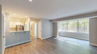 Located at 11711 S Laurel Dr in Laurel, MD, this three-bedroom, one-bathroom single-floor residence offers a thoughtfully designed layout with contemporary updates throughout. The open living room is a welcoming centerpiece, featuring light-toned hardwood-style flooring and a large picture window dressed with vertical blinds that floods the space with natural light and offers views of the surrounding greenery. The kitchen is fully renovated and well-appointed, showcasing crisp white shaker-style cabinetry, marble-look countertops, stainless steel appliances including a range, microwave, refrigerator, and dishwasher, and a pass-through window that connects to the living area. The three bedrooms are comfortably sized, with the primary bedroom offering plush carpeting, a ceiling fan, angled architectural beam detail, and a window that brings in natural light. The additional bedrooms share similar finishes with ceiling fans and carpeted floors. The bathroom is clean and functional, featuring a full tub-shower combination with gold-tone fixtures, a marble-look vanity countertop, and hardwood-style flooring. A hallway and closet complete the efficient floorplan. The home's neutral gray and white color palette, updated fixtures, and consistent finishes give it a fresh, move-in-ready appeal.