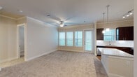 Located at 14940 Mueschke Rd in Cypress, TX, this single-story unit offers a thoughtfully designed open-concept layout that seamlessly connects the main living areas. The living room is bright and welcoming, featuring plush neutral carpeting, crown molding, a ceiling fan, and a bank of windows alongside a glass door that invites natural light and provides outdoor views. The space flows directly into the kitchen, which is outfitted with rich dark-wood cabinetry, granite countertops, a large island, stainless steel appliances including a French door refrigerator, electric range, and built-in microwave, plus wood-look flooring and a tile backsplash. The entryway transitions smoothly from hard flooring to carpet, anchored by pendant lighting from the adjacent kitchen.

The bedrooms are carpeted and include ceiling fans and windows with outdoor views, providing comfortable, well-lit retreats. The primary bathroom is a standout, featuring a dual-sink granite vanity with dark cabinetry, a glass-enclosed walk-in shower with large-format tile, and wood-look flooring. A secondary bathroom includes a soaking tub with tiled surround and wood-look flooring, completing the unit's practical and polished interior finishes.