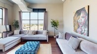 Located at 292 W Western Ave in Muskegon, Michigan, this contemporary single-floor unit showcases a distinctive industrial-chic aesthetic with soaring ceilings and exposed ductwork throughout. Rich hardwood flooring flows seamlessly across every room, anchoring the space with warmth and continuity.

The open-concept living area features generous natural light and large floor-to-ceiling windows that frame views of the surrounding Muskegon waterfront. The kitchen is well-appointed with sleek white cabinetry, a mosaic tile backsplash, stainless steel appliances including a gas range and built-in microwave, and an expansive granite-topped island with bar seating and stylish pendant lighting overhead.

The bedrooms are spacious and airy, each benefiting from soaring ceilings, exposed utility conduits that reinforce the industrial character, and large windows offering abundant natural light and exterior views. Ample closet storage is also provided.

The bathroom presents a clean, modern finish with a white vanity topped with granite counters, warm wood-tone flooring, a full shower with curtain enclosure, and a large mirror above the vanity. A sliding frosted-glass door adds a refined architectural detail.

Overall, the unit delivers a cohesive urban-modern living experience defined by high-end finishes, an open layout, and compelling views of Muskegon's waterfront.