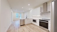 This thoughtfully designed one-bedroom, one-bathroom residence in Round Rock, TX offers a clean, modern aesthetic throughout its efficiently laid-out single floor. Light wood-tone flooring flows seamlessly across all areas, complementing the bright, neutral palette that defines the space.

The open-concept kitchen and living area serves as the heart of the home. The kitchen features flat-front white cabinetry extending to the ceiling, a white quartz peninsula with an undermount sink and matte black faucet, marble-look tile backsplash, under-cabinet lighting, and a full suite of stainless steel appliances including a dishwasher, range, built-in microwave, and refrigerator. Recessed lighting illuminates the space, while a glass-paneled door and adjacent window bring in natural light and provide access to the outdoors.

The bedroom is a generously sized, serene retreat with dual windows dressed in horizontal blinds, a ceiling fan, and ample wall space for flexible furniture arrangements. A dedicated closet provides convenient storage.

The bathroom is finished with a frameless glass walk-in shower clad in large-format white tile, a white vanity with clean-line drawers, and matte black hardware and fixtures throughout, adding a refined contrast to the otherwise bright interior.