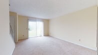 Located at 598 Colony Rd in Canal Fulton, Ohio, this multi-floor property offers a straightforward and functional layout across three levels. The main living area is generously sized, featuring plush wall-to-wall carpeting and a sliding glass door dressed with vertical blinds that opens to an outdoor view of the surrounding greenery, allowing natural light to fill the room. A staircase connects the floors, and additional carpeted rooms provide flexible space suitable for bedrooms or other uses, each with closet access and windows that bring in natural light.

The kitchen is equipped with white cabinetry, bold blue countertops, a gas range, and a full-size refrigerator. Tile flooring and a double sink complement the practical design, while a window overlooks the exterior. The full bathroom features tile flooring, a tub-shower combination with white subway tile surround, a vanity with blue countertop, and a large mirror.

The lower level presents an unfinished basement with concrete block walls, a utility sink, a sump pump, and exposed ceiling joists — offering substantial storage or the potential for future finishing. Throughout the home, neutral warm tones and consistent finishes create a cohesive, move-in ready environment.