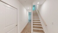 Located at 55 Summer St in South Walpole, MA, this thoughtfully designed 2-bedroom, 3-bathroom residence spans three floors, offering a well-organized layout with dedicated spaces for living, sleeping, and storage. The entry level houses a private garage with automatic opener, providing secure, convenient parking.

The main living floor features an open-concept kitchen and living room filled with natural light. The kitchen is outfitted with stainless steel appliances, two-tone cabinetry combining white upper cabinets and warm wood lower cabinets, quartz countertops, a tile backsplash, and gold-accented hardware and pendant lighting. The adjoining living area showcases a striking herringbone-patterned hardwood floor, a ceiling fan, and glass doors opening to a private balcony with tree-lined views.

The upper floor hosts both bedrooms, each featuring light hardwood flooring, ceiling fans, and generous closet space. The primary bedroom includes a walk-in closet. All three bathrooms are finished with wood-grain vanities, white quartz countertops, gold hardware, and neutral tile flooring. One full bath features a tub-shower combination with tiled surround. Throughout the residence, clean white walls, modern fixtures, and consistent finishes create a bright, contemporary ambiance.
