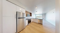 This contemporary apartment, located at 2222 15th Ave W in Seattle, offers 780 square feet of efficiently designed living space. The single-story layout comprises two bedrooms, including a primary bedroom of 150 square feet, and two full bathrooms. The heart of the home is an open-concept kitchen, showcasing a blend of white and wood-toned cabinetry, stainless steel appliances, and a practical L-shaped countertop configuration. The kitchen's design integrates seamlessly with the living areas, enhancing the sense of spaciousness.

Throughout the apartment, light wood flooring creates a warm, cohesive aesthetic. The bedrooms feature large windows that invite natural light, complementing the neutral wall tones. Both bathrooms are outfitted with modern fixtures, including glass-enclosed showers and wood vanities topped with sleek counters. A notable feature is the inclusion of a dedicated closet space, enhancing the apartment's storage capabilities.

The overall design emphasizes clean lines and a minimalist approach, with recessed lighting and simple, functional hardware choices. The apartment's layout maximizes the use of its 780 square feet, creating a comfortable and stylish urban living space in the heart of Seattle.