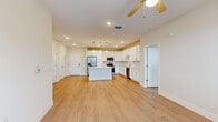 Located at 295 Royal Tern Cir, this single-story, 3-bedroom, 2-bathroom home offers a thoughtfully designed open-concept layout that maximizes comfort and functionality. Light wood-style flooring flows seamlessly throughout the entire residence, creating a bright, cohesive aesthetic.

The heart of the home is the modern kitchen, which features white shaker cabinetry with brushed nickel hardware, light quartz countertops, a center island with pendant lighting, and a full suite of stainless steel appliances including a refrigerator, range, microwave, and dishwasher. The kitchen opens directly into the living area, which is equipped with a ceiling fan and access to the outdoors through a windowed door, allowing for natural light to fill the space.

The spacious primary bedroom includes a walk-in closet with wire shelving and its own ceiling fan. The additional bedrooms are well-sized, each featuring large windows with exterior views and ceiling fans. The bathrooms are finished with white vanity cabinetry, quartz countertops, and tile-surround tub-shower combinations. A dedicated walk-in closet with multi-level wire shelving provides ample storage. The home's clean, neutral palette and consistent finishes create a bright, move-in-ready atmosphere throughout.