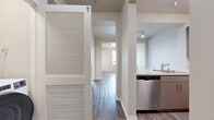 This 610-square-foot, one-bedroom, one-bathroom apartment at 8200 Haven Avenue in Rancho Cucamonga, CA offers a clean, modern aesthetic throughout its single-floor layout. Wood-style luxury vinyl plank flooring flows consistently across the living room, bedroom, hallway, kitchen, and bathroom, tying the space together with a cohesive, contemporary look.

The living room is bright and open, featuring a ceiling fan, neutral-toned walls, and a sliding glass door that leads to a private balcony with outdoor views of palm trees and the surrounding area. Additional windows allow for generous natural light throughout the day.

The kitchen is well-appointed with modern taupe flat-front cabinetry, white quartz-style countertops, a stainless steel sink, and a full suite of stainless steel appliances including a gas range, over-the-range microwave, and refrigerator.

The 130-square-foot bedroom includes a ceiling fan, ample wall space, and connects directly to the bathroom. The bathroom features a sleek single-sink vanity with white countertops, modern cabinetry with silver hardware, dual mirrors, and access to a dedicated walk-in closet with built-in rod shelving. A hallway connects the main living areas, completing the efficient and functional floor plan.