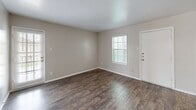 This 650 square foot apartment in Houston, TX, offers a well-designed living space with modern amenities. The single-floor layout comprises one bedroom, one bathroom, and an open-concept living area. The primary bedroom, measuring 180 square feet, provides ample space and includes a ceiling fan and carpeted flooring for comfort.

The bathroom features a clean, white design with a combination tub/shower, toilet, and vanity. The kitchen boasts sleek cabinetry, granite countertops, and stainless steel appliances, creating an efficient cooking space. The living and dining areas flow seamlessly, showcasing durable wood-look flooring that extends throughout the main living spaces.

Large windows in the living room and bedroom allow natural light to flood the space, while plantation shutters offer privacy control. The apartment's neutral color palette, primarily in shades of white and light gray, creates a bright and airy atmosphere.

Additional features include a ceiling fan in the living area, recessed lighting, and a pendant light fixture in the dining space. The unit also offers closet space for storage. Overall, this apartment combines functionality with modern aesthetics, providing a comfortable living environment in a compact footprint.
