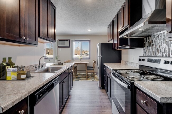 Elevate your living at St. Anthony Group with this modern kitchen featuring sleek cabinetry and stainless steel appliances. Enjoy spacious layouts and convenient amenities ideal for your lifestyle. Schedule your tour today and see for yourself! - Diamond Eight Terrace