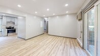 Located at 149 Ashford Center Rd in Ashford, Connecticut, this single-floor unit has been thoughtfully renovated with clean, modern finishes throughout. Light wood laminate flooring runs consistently across all rooms, creating a bright and cohesive aesthetic complemented by crisp white walls and gray baseboards.

The open living area is illuminated by recessed lighting and features a wall-mounted AC unit alongside baseboard heaters. Sliding glass doors lead directly to a private deck overlooking lush greenery, filling the space with natural light and offering pleasant outdoor views.

The kitchen is well-appointed with gray shaker-style cabinetry, granite-look countertops, a subway tile backsplash, and a full suite of stainless steel appliances including a range, dishwasher, refrigerator, and sink. Natural light enters through a window above the sink, adding to the room's airy feel.

The bedrooms are comfortably sized, each featuring windows with blinds that frame views of the surrounding trees, baseboard heating, and light-filled interiors. One bedroom includes a built-in closet with shelving for added storage.

The bathroom is a standout feature, finished with large-format wood-look and stone-look tile, a soaking tub, a rain showerhead, a recessed niche, and brushed nickel fixtures, delivering a spa-like atmosphere.